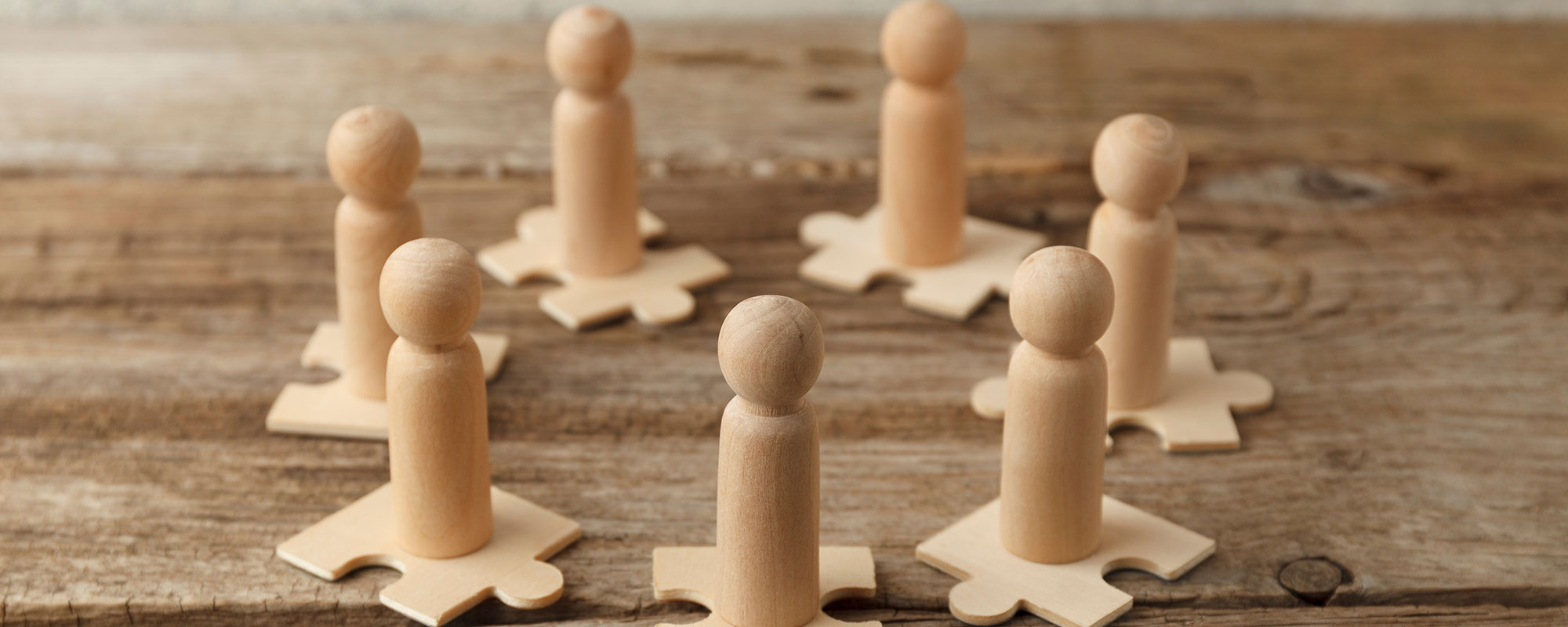 Wooden Figure On Puzzle Pieces Wooden Figure On Puzzle Pieces